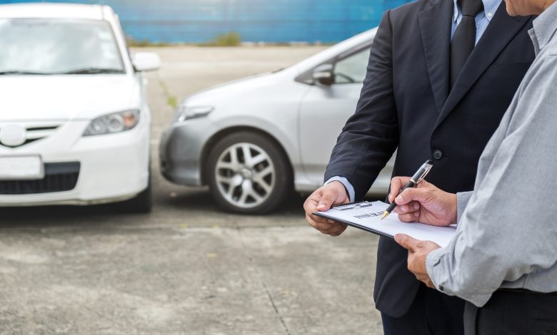 Insurance Agent Examine Damaged Car And Customer Filing Signatur