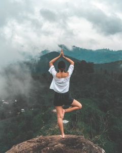 a woman standing on edge of a cliff